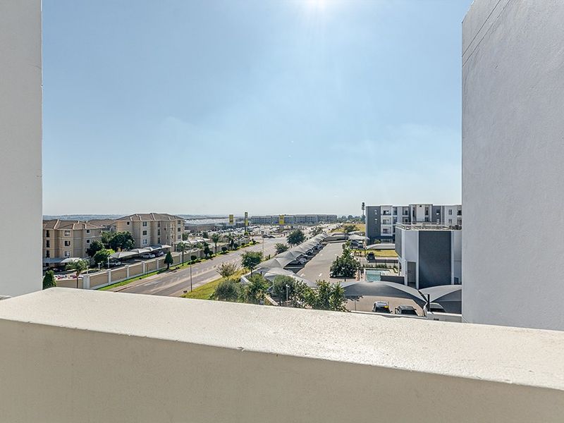 An elevated view overlooking the surrounding residential complex, parking areas, and neighbourhood from the apartment balcony.