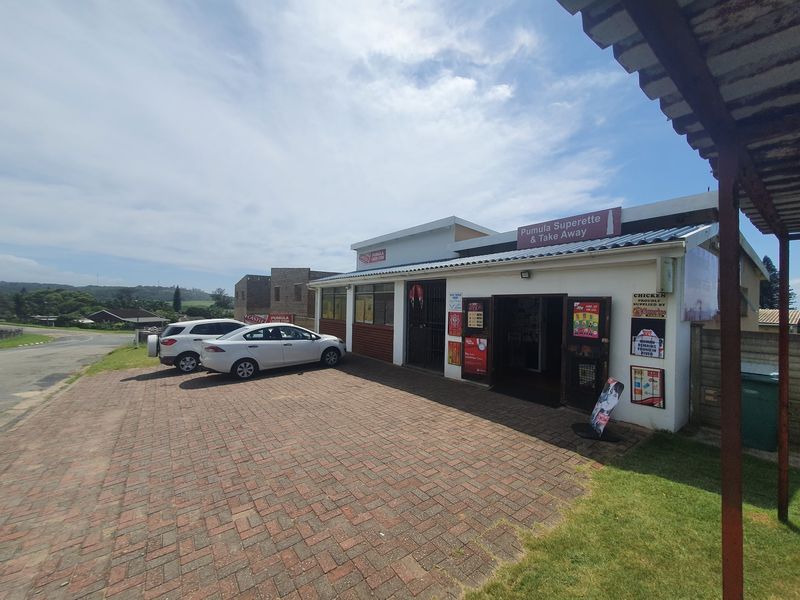 Front exterior view of a commercial superette and take-away shop featuring a paved parking area and prominent signage.