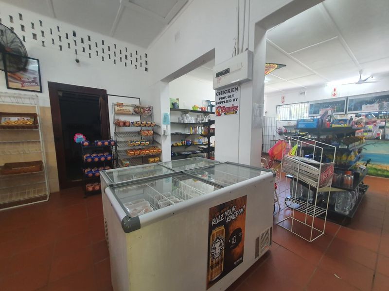 Commercial retail space featuring tiled flooring, built-in shelving units, and ventilation brickwork, suitable for a small convenience store or retail outlet.