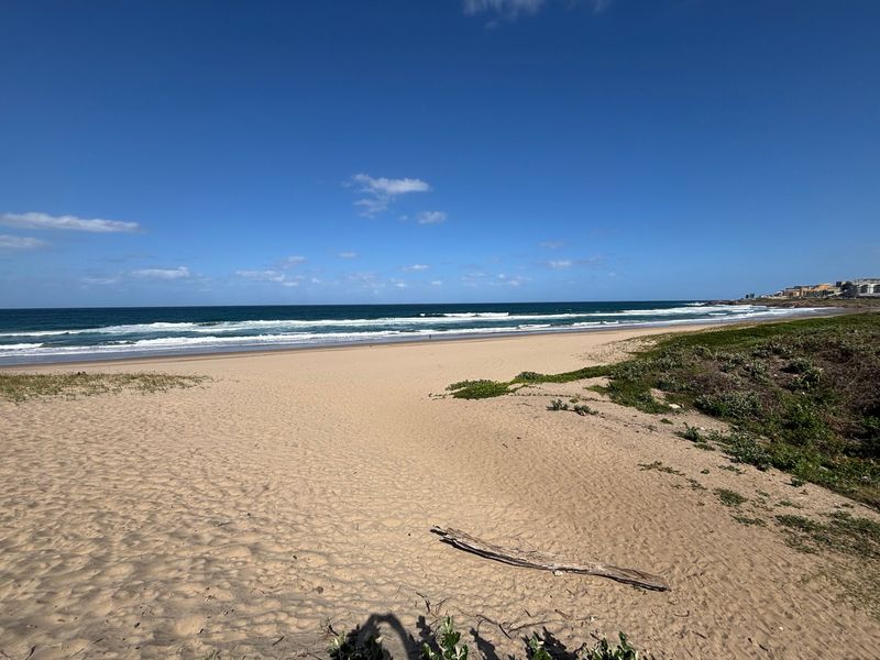 A scenic view of the sandy beach and ocean coastline, showcasing the natural surroundings of the property location.