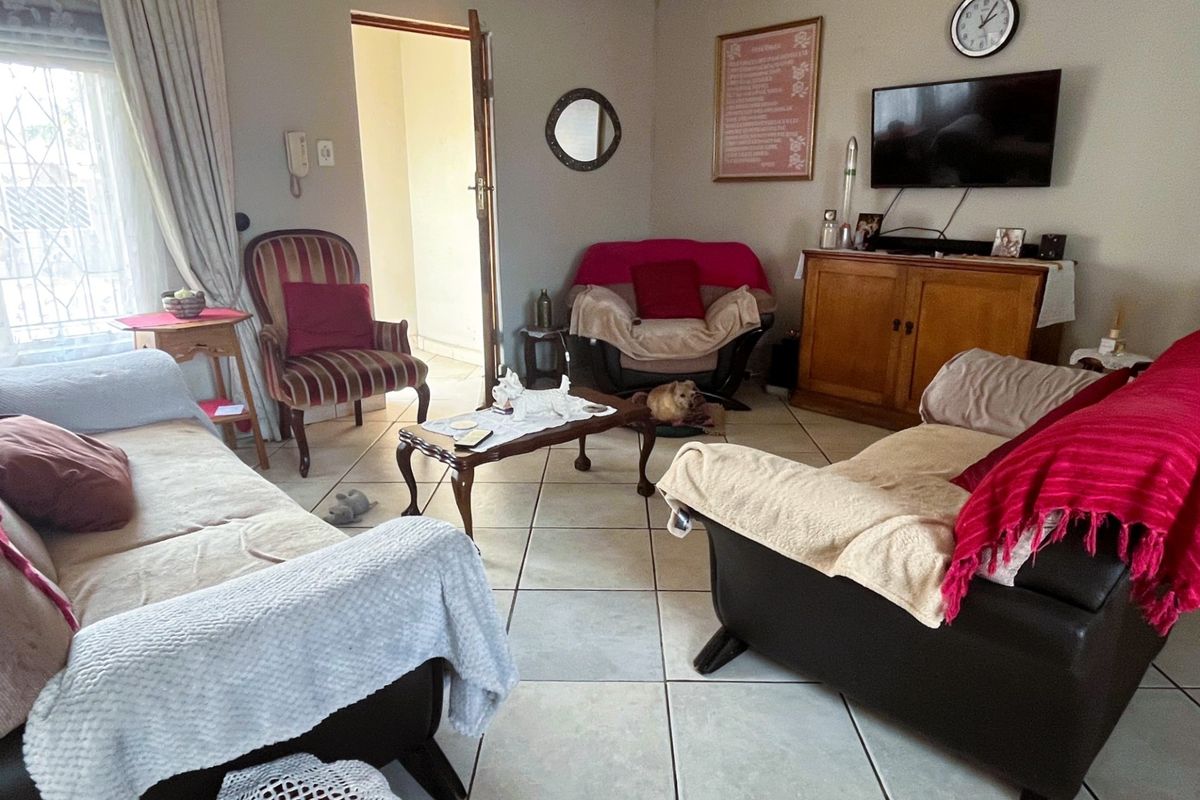 A living room featuring tiled flooring and access to an adjoining room, providing a functional and lived-in space.