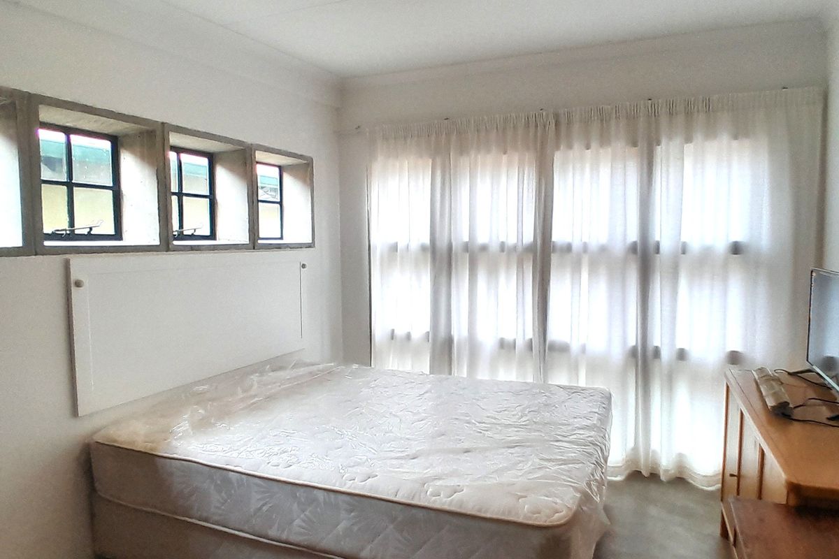 A bedroom featuring recessed windows and large floor-to-ceiling curtains, providing natural light and a neutral foundation for interior design.