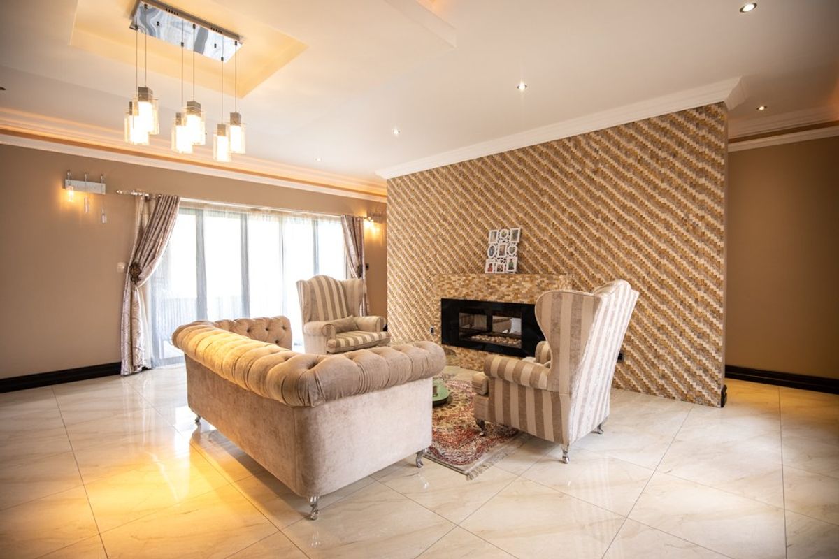 Spacious living room featuring polished tile flooring, a decorative feature wall with a built-in fireplace, and elegant recessed ceiling lighting.
