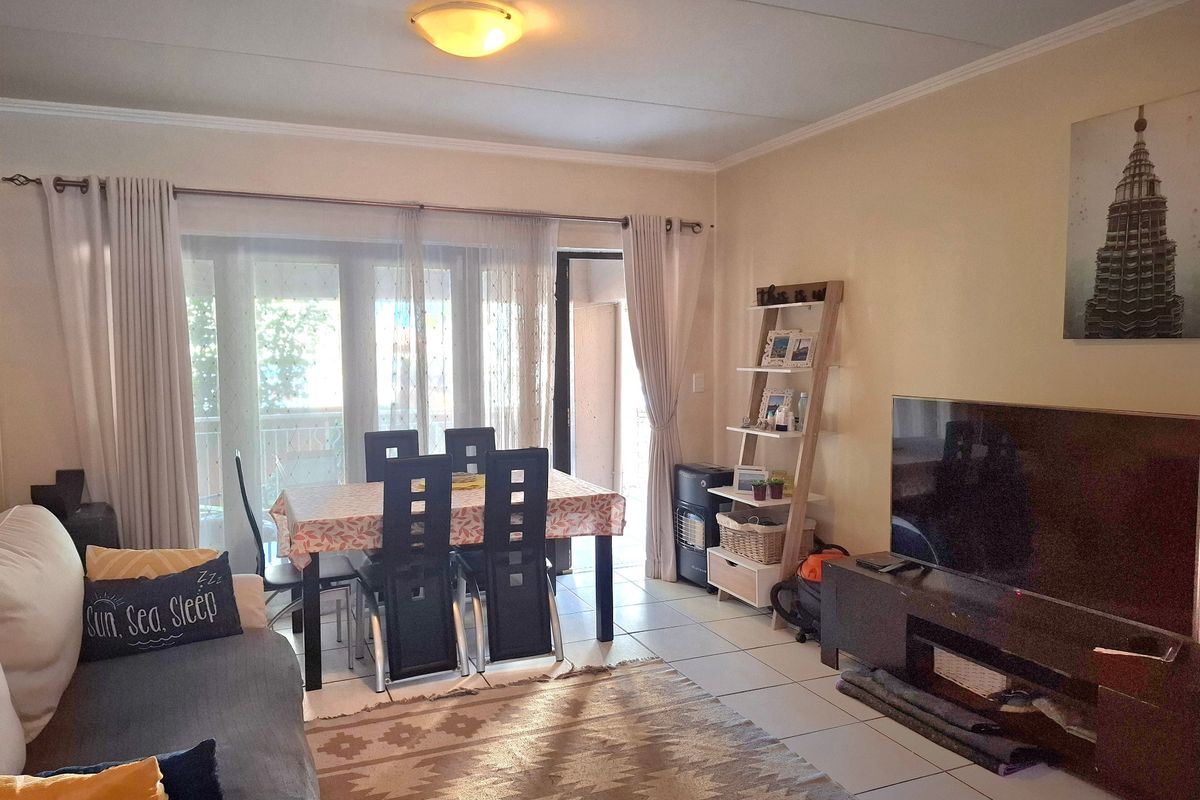 Open-plan living and dining area featuring tiled flooring and a large sliding glass door providing access to the balcony.
