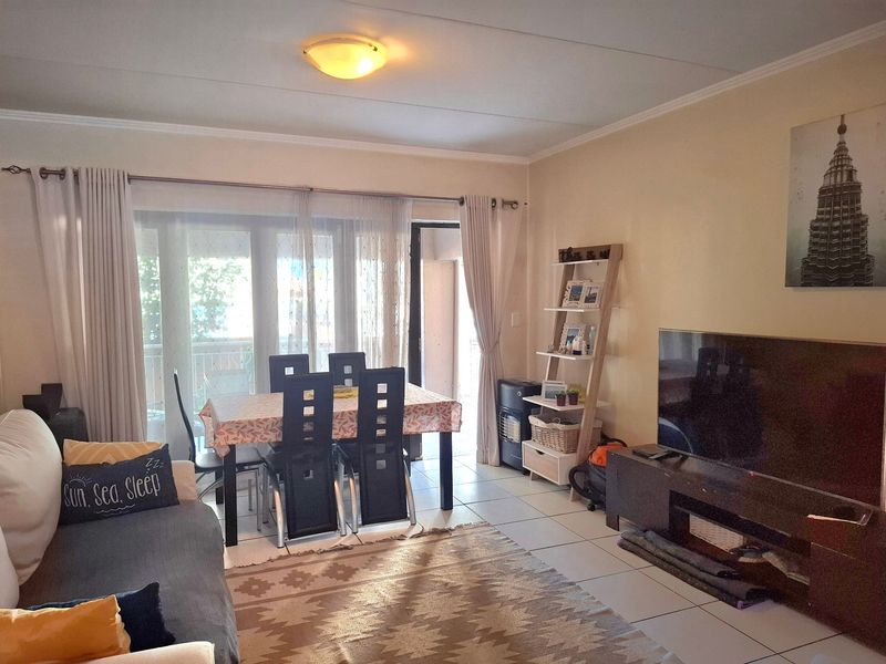 Open-plan living and dining area featuring tiled flooring and a large sliding glass door providing access to the balcony.