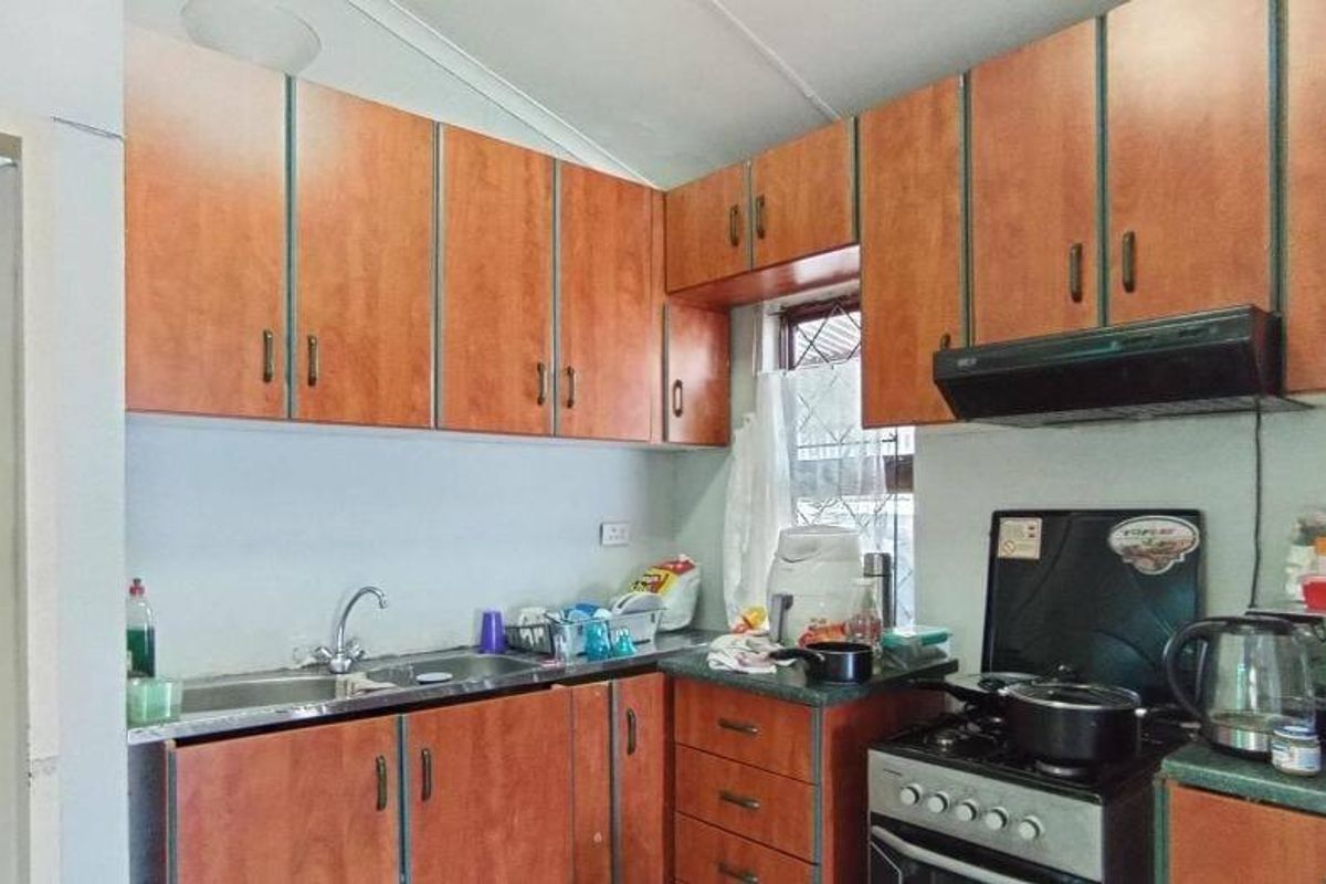 A functional kitchen featuring laminate cabinetry, a stainless steel sink, and a built-in gas stove with an extractor fan.