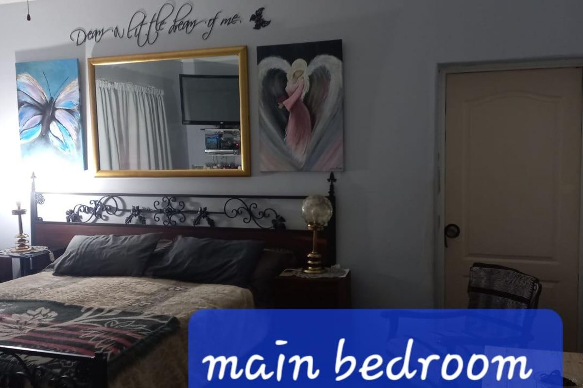 A bedroom featuring a wrought iron bed frame and a standard interior panel door.