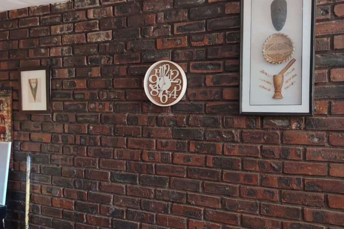 A living area featuring a prominent exposed brick feature wall, providing a rustic texture to the interior space.