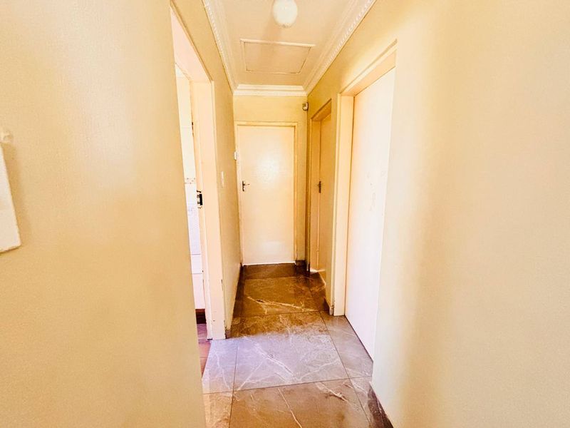 A functional hallway featuring tiled flooring and access to multiple internal rooms, providing a central circulation space within the home.