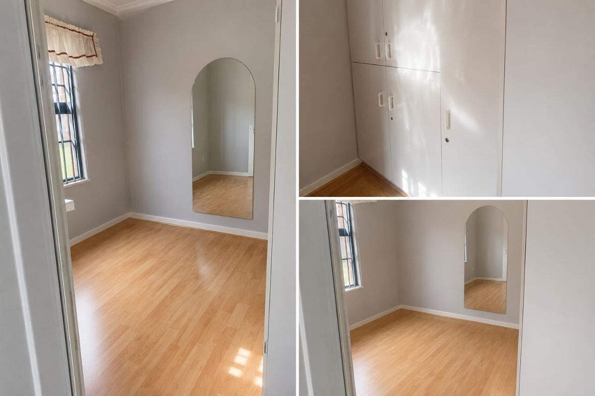 A bright, empty bedroom featuring laminate flooring, built-in storage cupboards, and an arched wall mirror.