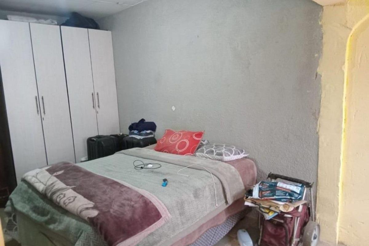 A bedroom featuring a built-in wardrobe and unfinished wall surfaces requiring plastering and painting to complete the room's aesthetic.