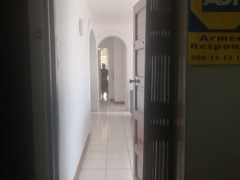 An entry area featuring tiled flooring and arched architectural details leading into the interior of the apartment.