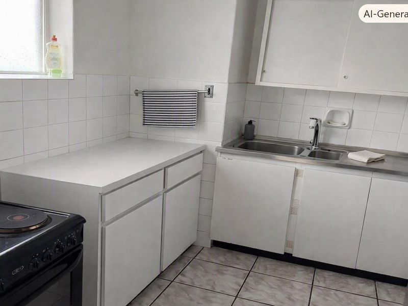 A compact kitchen featuring white cabinetry, a stainless steel sink, tiled backsplash, and tiled flooring, offering a functional but dated layout.