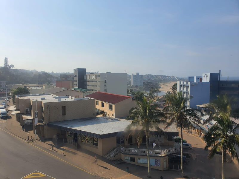An elevated view overlooking the surrounding urban neighborhood, street infrastructure, and coastal landscape.