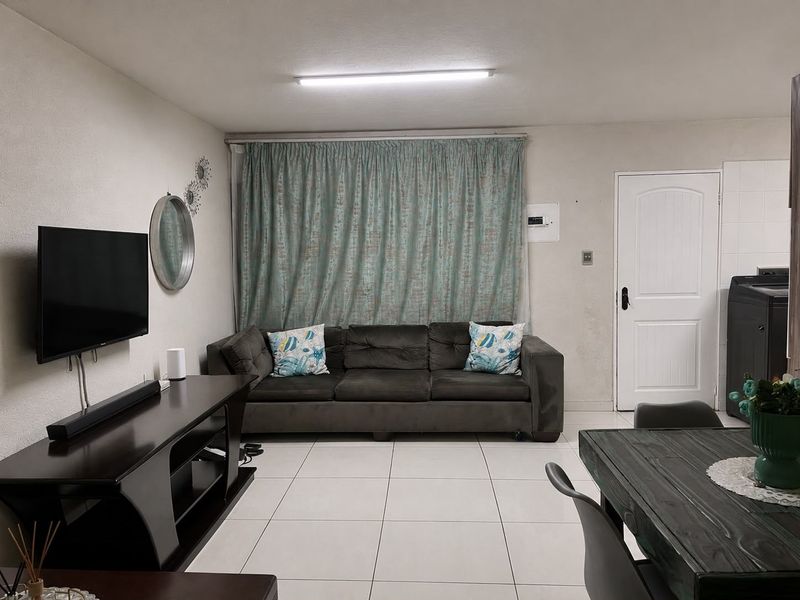 Open plan living area featuring tiled flooring and neutral wall finishes, providing a functional space for relaxation and dining.