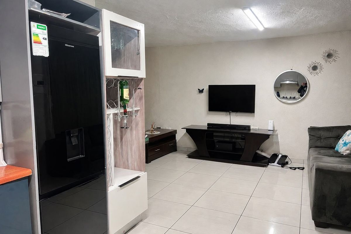 A living room area featuring neutral ceramic floor tiles and a standard ceiling light fixture.