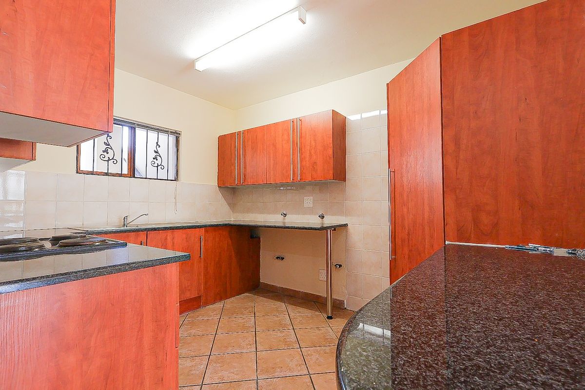 A functional kitchen featuring laminate cabinetry, granite countertops, ceramic tile backsplash, and tiled flooring, offering a clean and practical workspace.