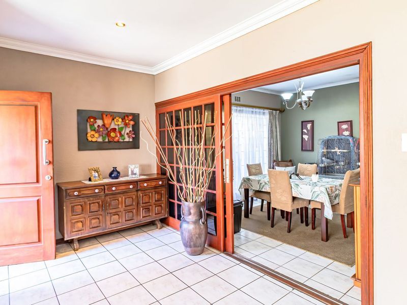 A living area featuring tiled flooring and a large sliding wooden door connecting to the adjacent dining room.