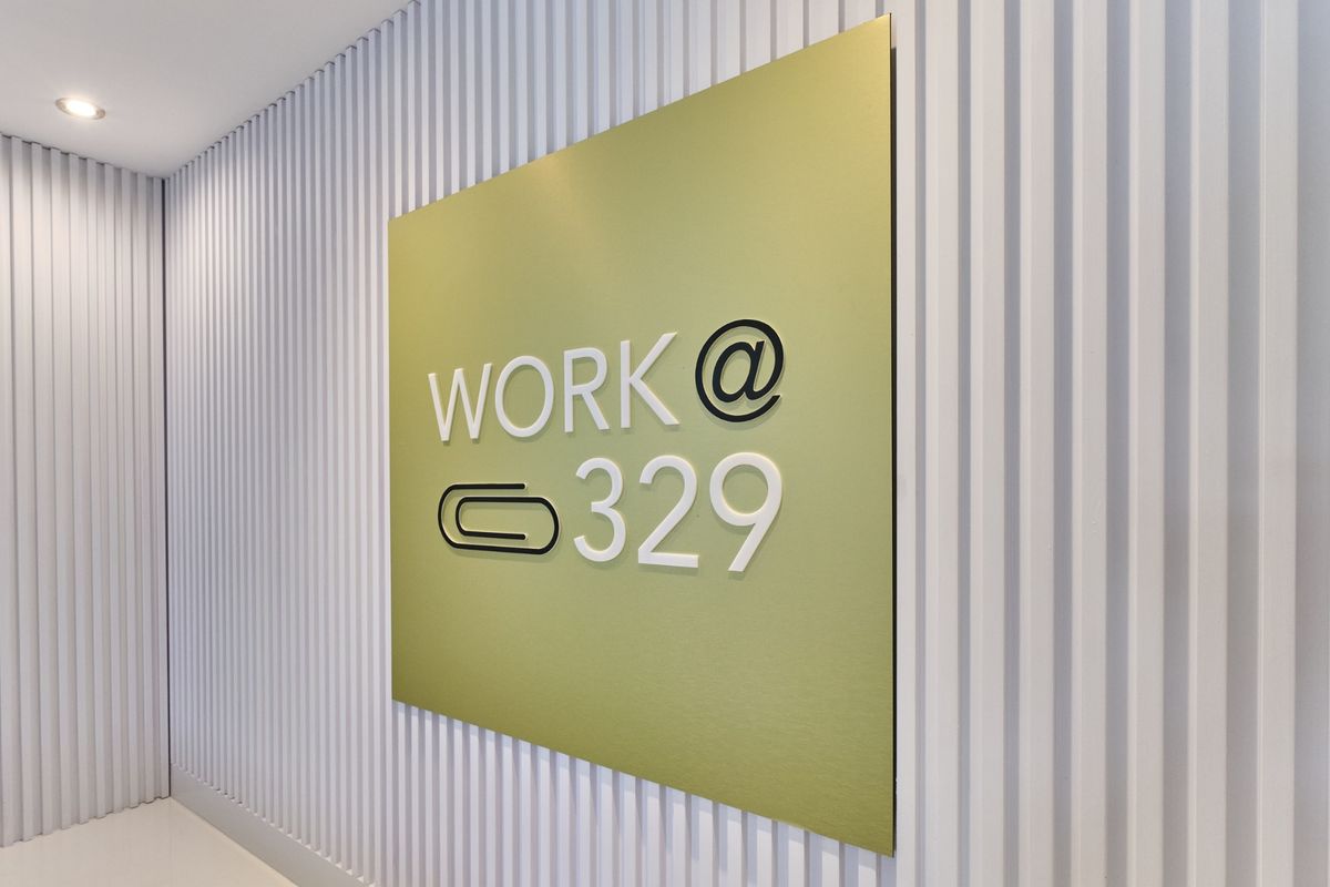 A modern commercial hallway featuring clean vertical slat wall paneling and professional custom signage.