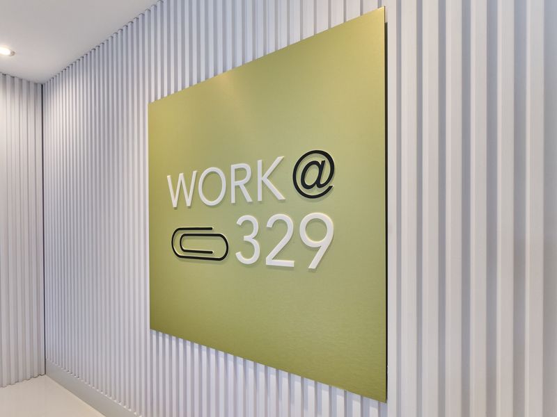A modern commercial hallway featuring clean vertical slat wall paneling and professional custom signage.
