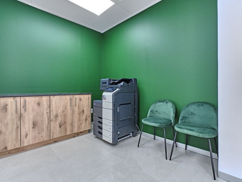 A functional office space featuring built-in cabinetry with a laminate countertop, tiled flooring, and recessed ceiling lighting.