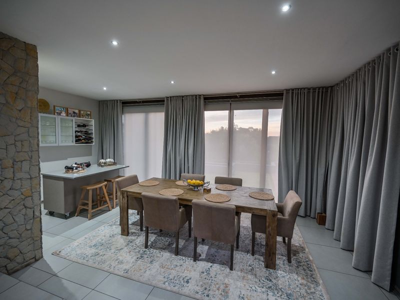 Spacious dining area featuring a stone accent wall, recessed lighting, and large sliding glass doors that provide access to the exterior.