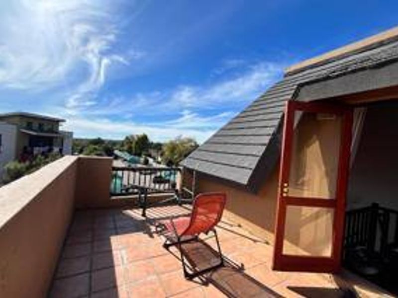 A sunny, open-air balcony featuring tiled flooring and direct access to the interior, offering an elevated outdoor space.