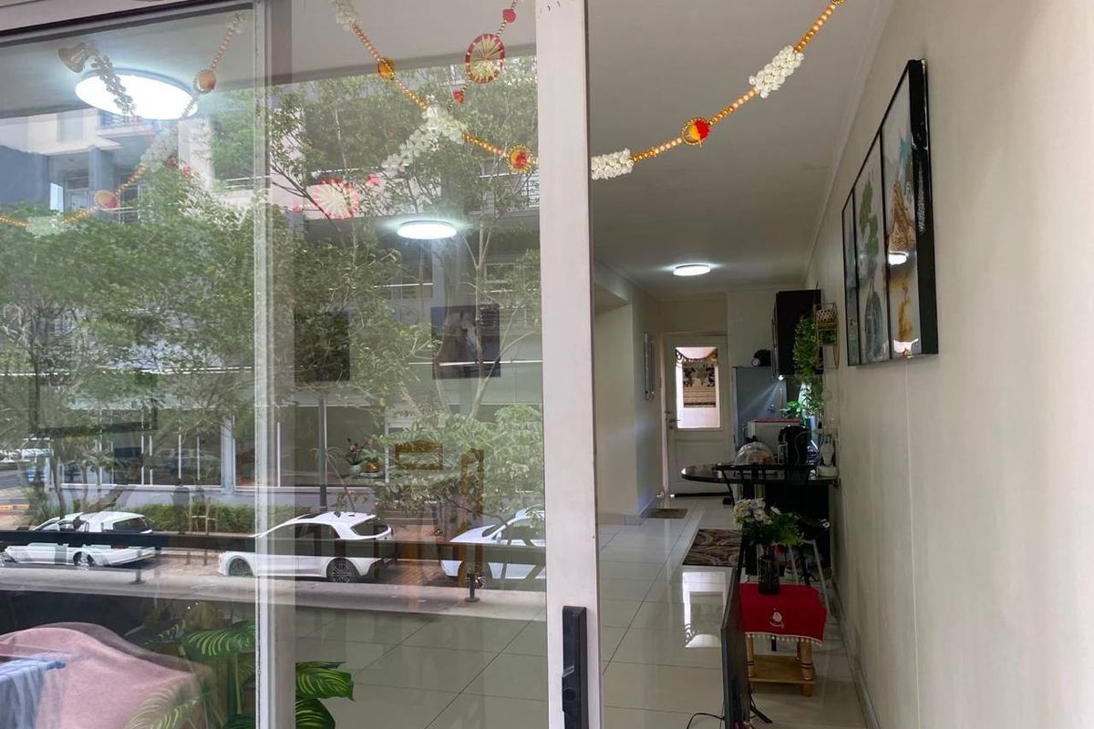 A view from a balcony looking into a living area featuring tiled flooring and sliding glass doors.