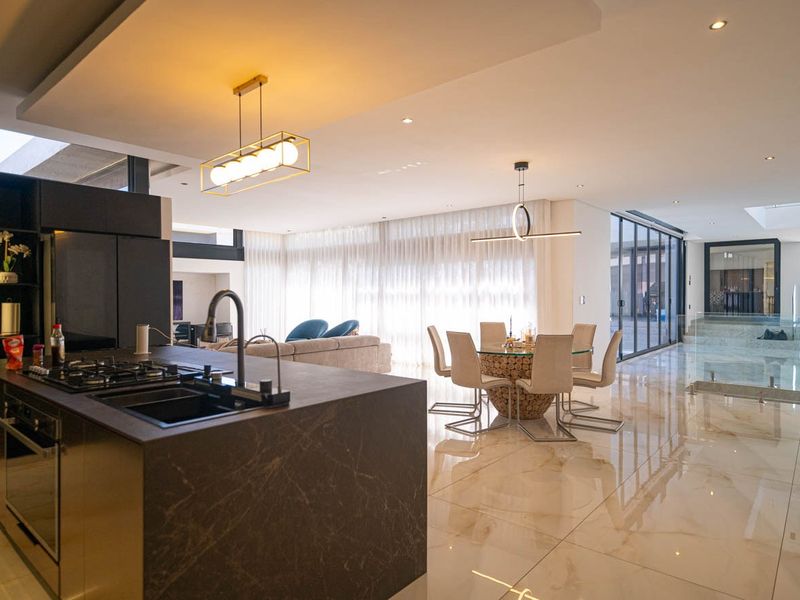 Spacious open-plan living area featuring a modern kitchen with a large island, high-end finishes, and seamless flow to the dining and lounge spaces.