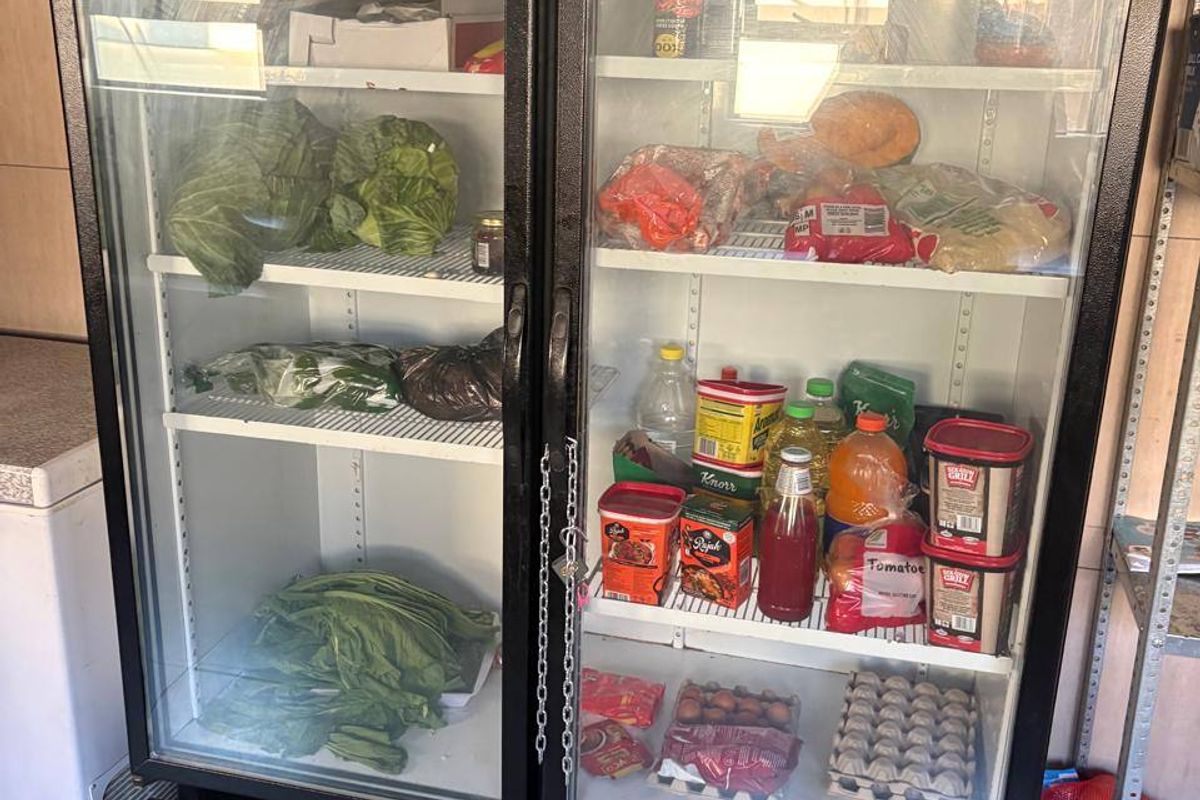 A commercial-grade double glass-door refrigerator unit positioned in a tiled kitchen area, used for cold storage of food supplies.