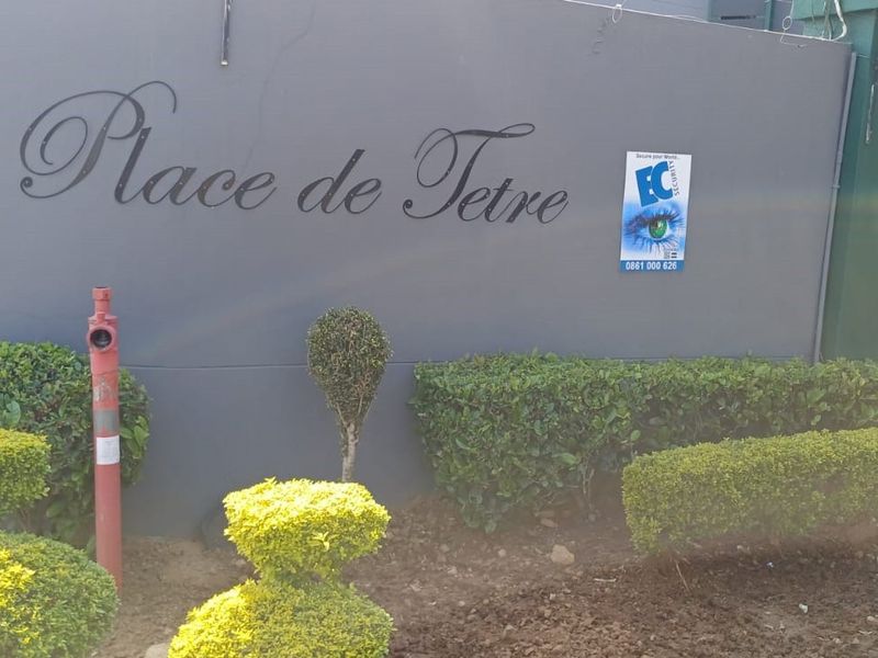 Exterior view of the Place de Tetre complex boundary wall featuring signage, fire hydrant, and water infrastructure.