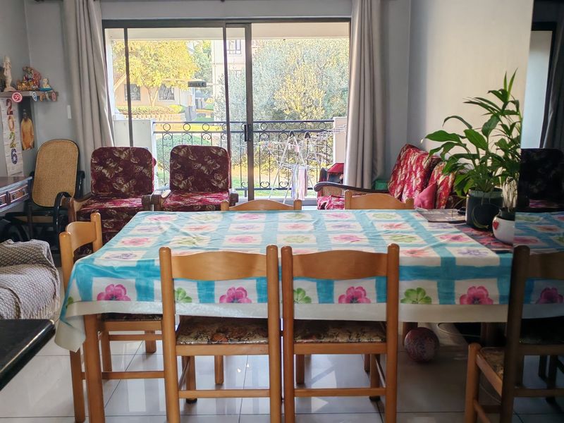 Dining area featuring tiled flooring, a large mirrored wall panel, and sliding glass doors providing access to an outdoor balcony.