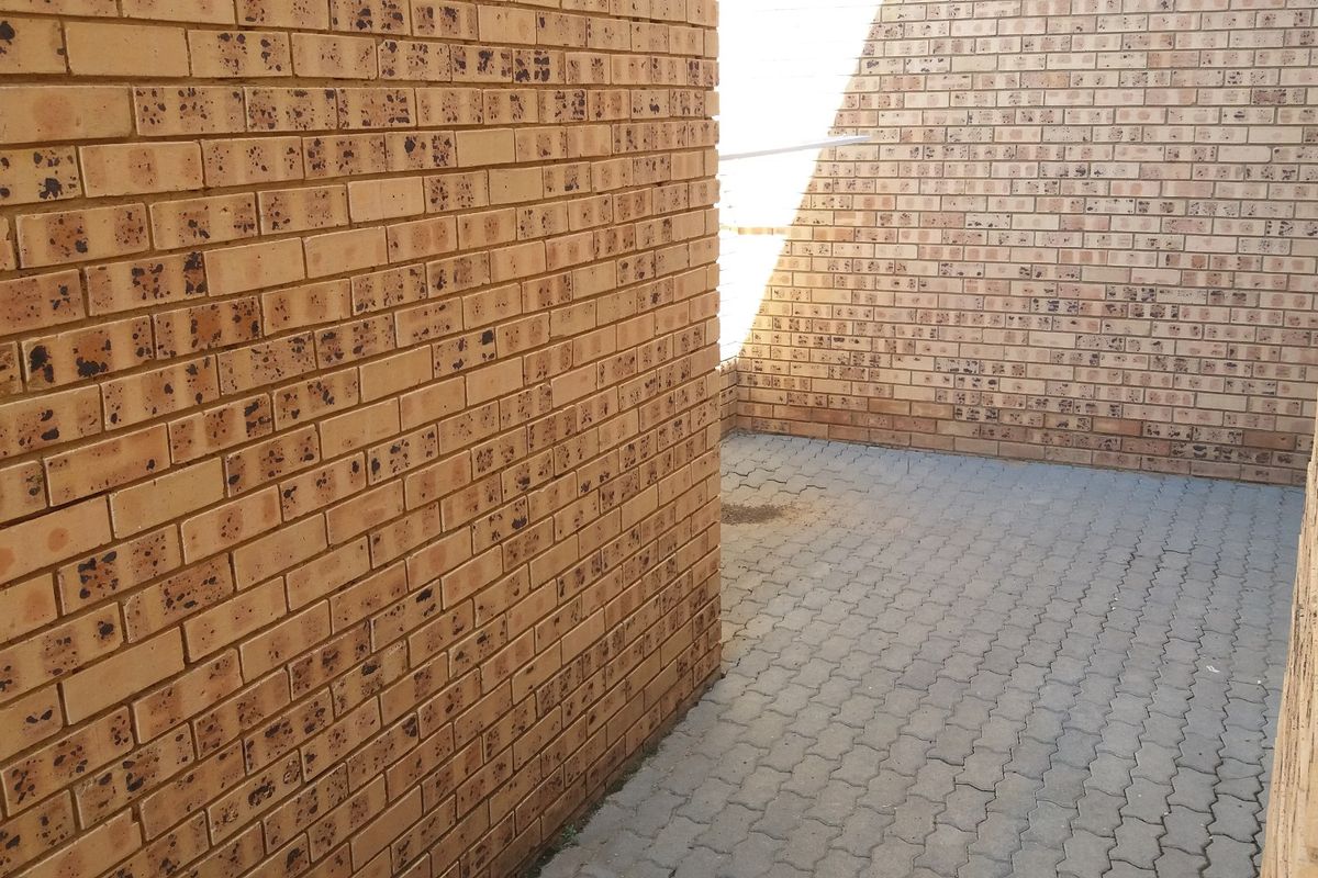 A private paved courtyard area enclosed by face brick boundary walls, providing a low-maintenance outdoor space.