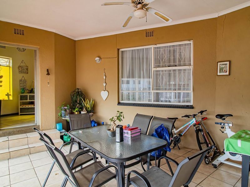 A covered patio area featuring tiled flooring, a ceiling fan, and direct access to the interior of the home.