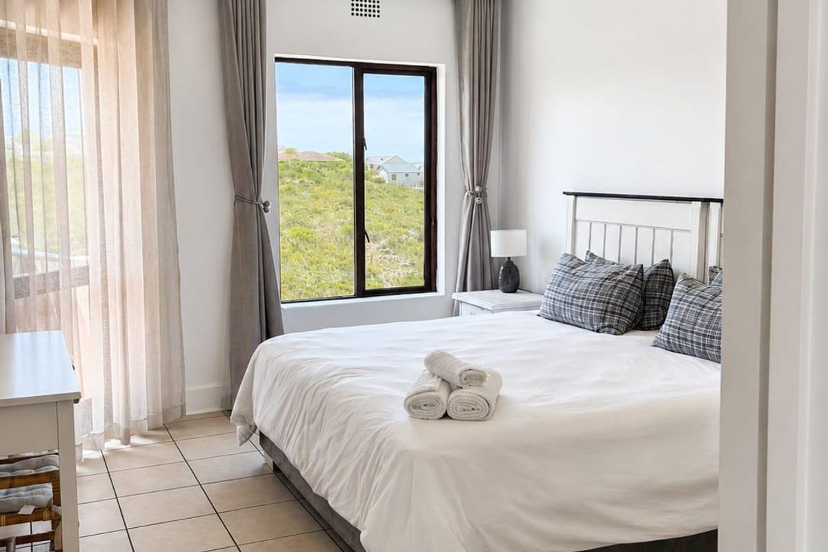 A bright and well-maintained bedroom featuring tiled flooring, a ceiling fan, recessed lighting, and direct access to an outdoor area through a sliding glass door.