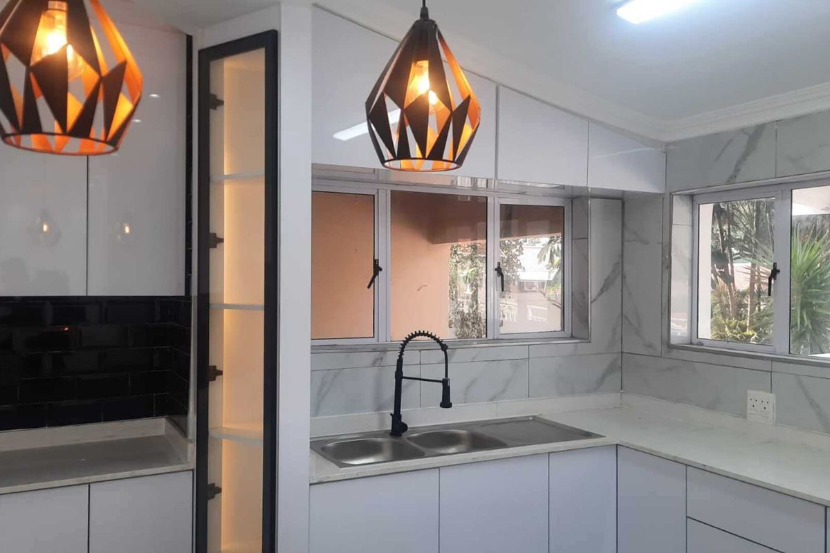 Modern kitchen featuring white gloss cabinetry, marble-look wall tiles, stone countertops, and a double bowl sink with a contemporary black mixer tap.