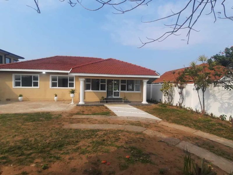 Front view of a single-story house featuring a tiled roof, concrete columns at the entrance, and a paved walkway leading to the front door.