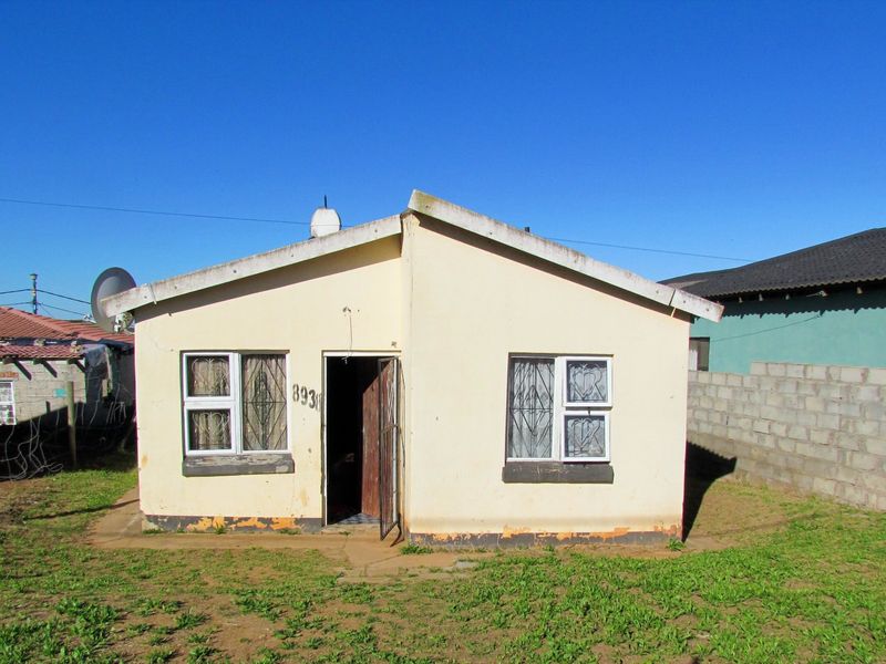 Front elevation of a single-story residential house featuring security gates and aluminium window frames, showing signs of exterior wear and maintenance requirements.
