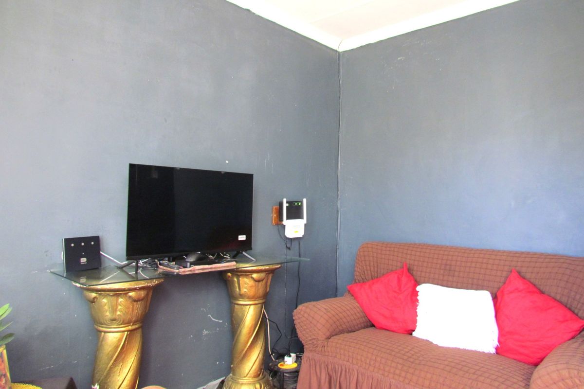 A living room area featuring dark painted walls and corner space.