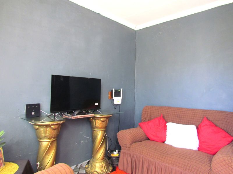 A living room area featuring dark painted walls and corner space.