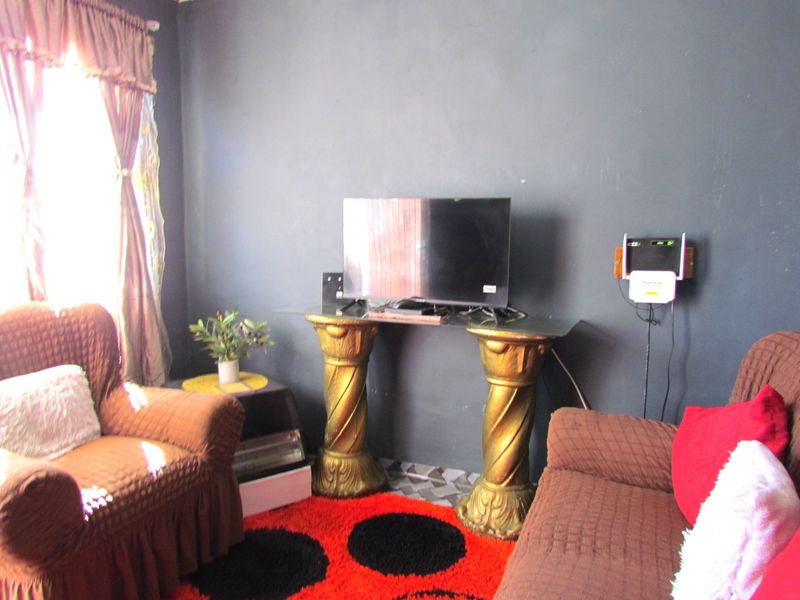 A living room area featuring dark painted walls and natural light from a side window.