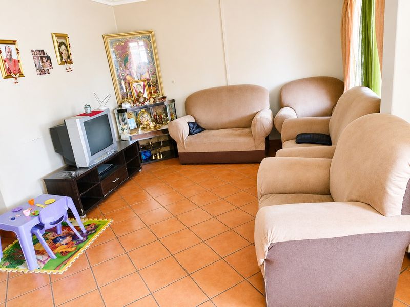 A living room area featuring ceramic tile flooring and neutral wall finishes, providing a functional space for relaxation.