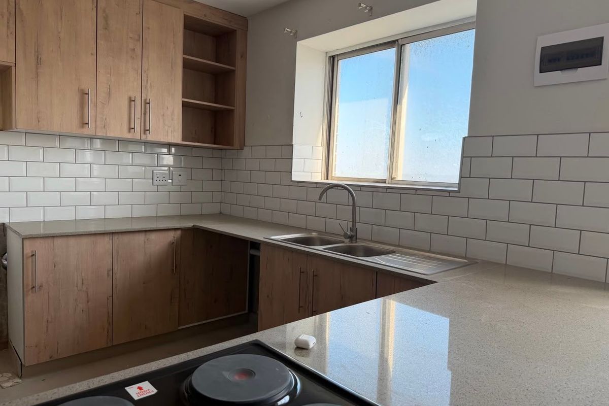 Modern kitchen featuring wood-look cabinetry, stone countertops, subway tile backsplash, and a built-in electric hob with a double bowl sink.