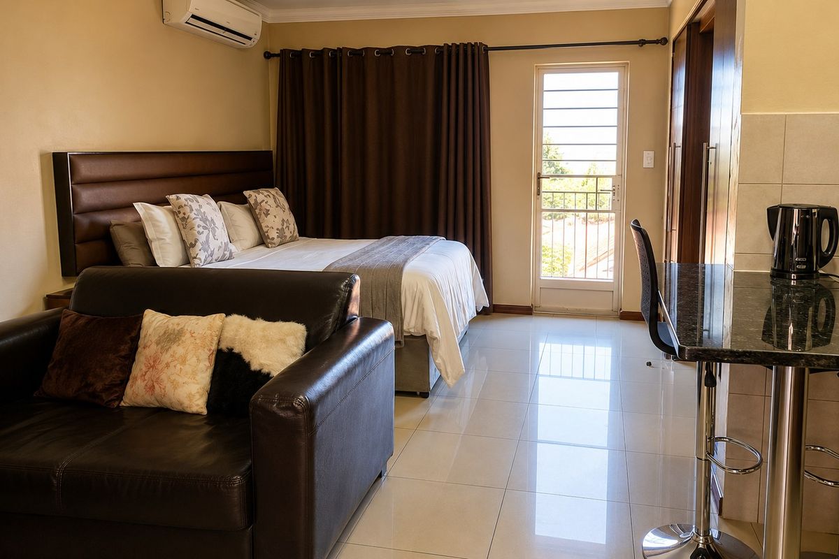 A well-maintained bedroom featuring tiled flooring, built-in cupboards, a granite breakfast bar, and direct access to a private balcony via a security door.
