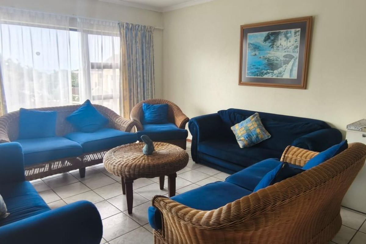 A spacious living room featuring tiled flooring and a large sliding glass door that provides ample natural light.