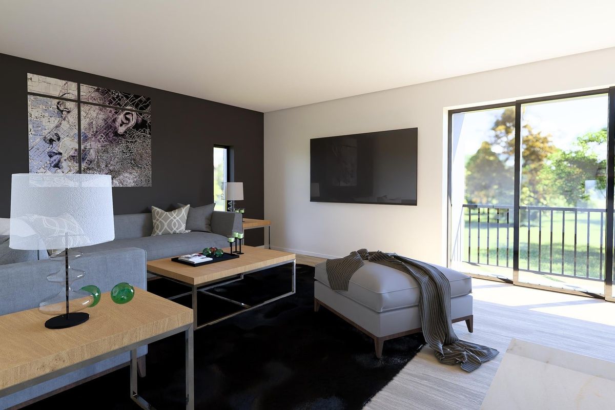 Modern living room featuring large sliding glass doors that open to a balcony, providing ample natural light and a seamless indoor-outdoor flow.