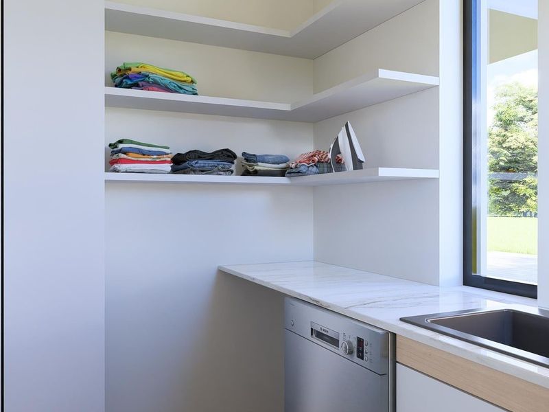 A modern, clean laundry area featuring built-in shelving, a stone countertop with an integrated sink, and wood-look flooring.