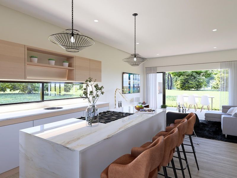 Modern open-plan kitchen and living area featuring a large stone island, sleek cabinetry, and seamless access to the outdoor patio through sliding glass doors.