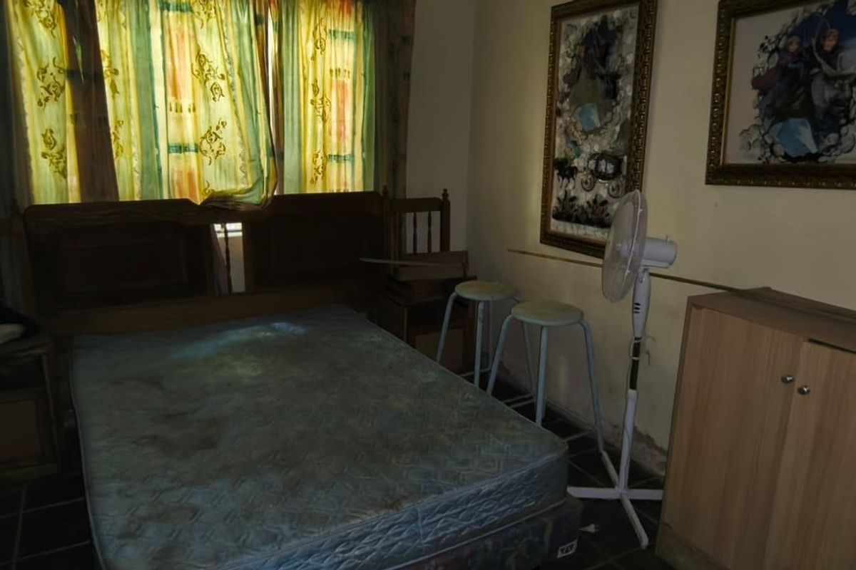 A bedroom featuring tiled flooring and visible wall surface wear, requiring cosmetic updates to improve the overall condition and appeal of the space.
