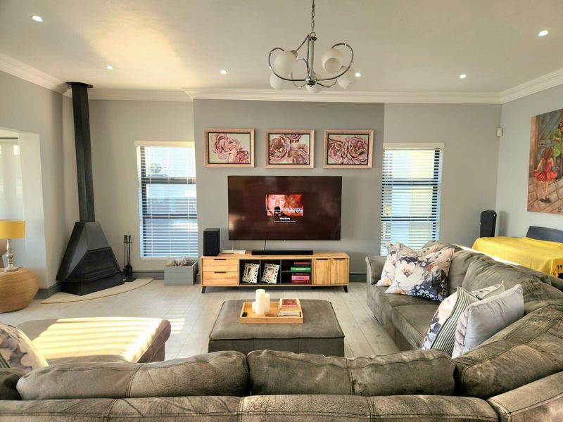 A well-maintained living room featuring a modern freestanding fireplace, recessed lighting, and neutral finishes, creating a comfortable and inviting atmosphere.